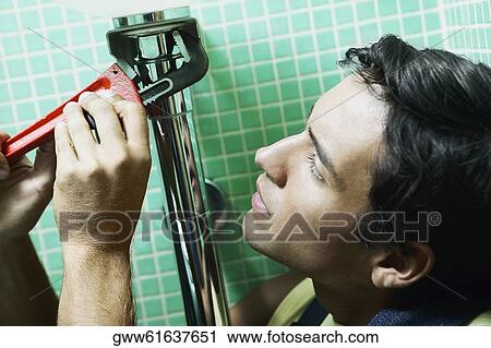 Close-up of a plumber working with an adjustable wrench View Large Photo Image Stock Image - Close-up of a plumber working with an adjustable wrench. Fotosearch