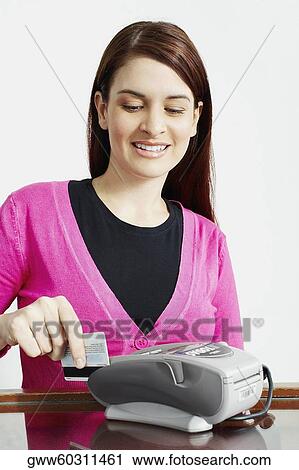 Stock Image - Close-up of a sales clerk using a credit card reader. Fotosearch