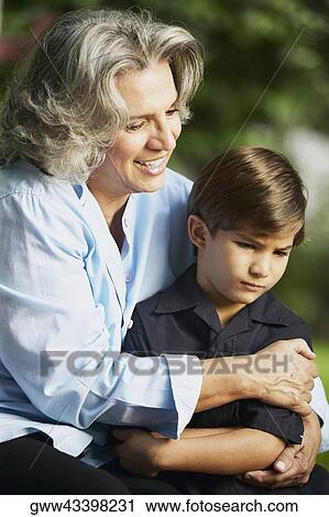 Stock Image - Close-up of a senior woman smiling and hugging her grandson. Fotosearch