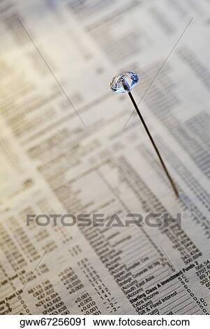 Stock Image - Close-up of a straight pin on a financial newspaper. Fotosearch