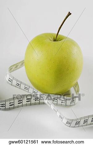 Close-up of a tape measure around a green apple View Large Photo Image Stock Image - Close-up of a tape measure around a green apple. Fotosearch