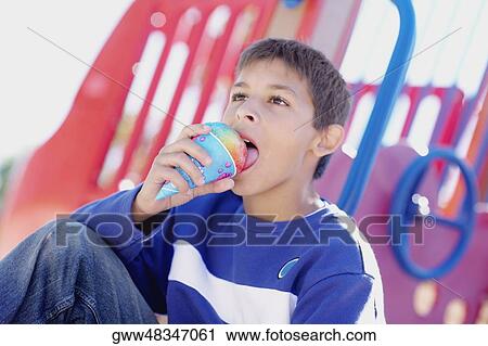 Close-up of a teenage boy eating an ice-cream cone View Large Photo Image Stock Image - Close-up of a teenage boy eating an ice-cream cone. Fotosearch