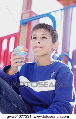 Close-up of a teenage boy holding an ice-cream cone View Large Photo Image Stock Image - Close-up of a teenage boy holding an ice-cream cone. Fotosearch