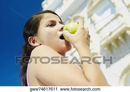 Close-up of a teenage girl eating a green apple View Large Photo Image Stock Image - Close-up of a teenage girl eating a green apple. Fotosearch