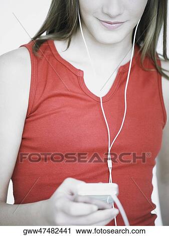 Close-up of a teenage girl listening to an MP3 player View Large Photo Image Stock Image - Close-up of a teenage girl listening to an MP3 player. Fotosearch
