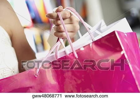 Close-up of a woman holding shopping bags View Large Photo Image Stock Image - Close-up of a woman holding shopping bags. Fotosearch