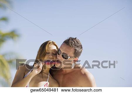 Close-up of a young couple eating an ice-cream View Large Photo Image Stock Image - Close-up of a young couple eating an ice-cream. Fotosearch