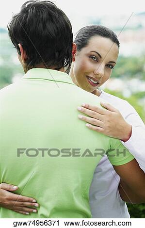 Stock Image - Close-up of a young couple embracing each other. Fotosearch