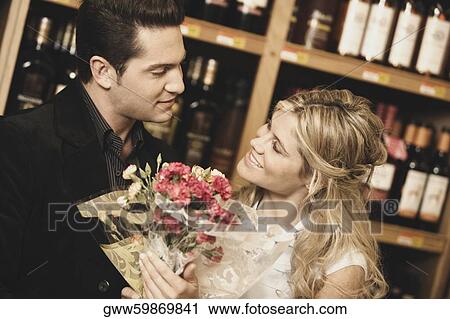 Close-up of a young couple looking at each other in a liquor store View Large Photo Image Stock Image - Close-up of a young couple looking at each other in a liquor store. Fotosearch