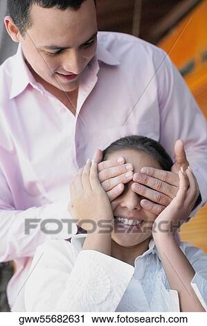 Close-up of a young man covering a teenage girl's eyes View Large Photo Image Stock Image - Close-up of a young man covering a teenage girl's eyes. Fotosearch