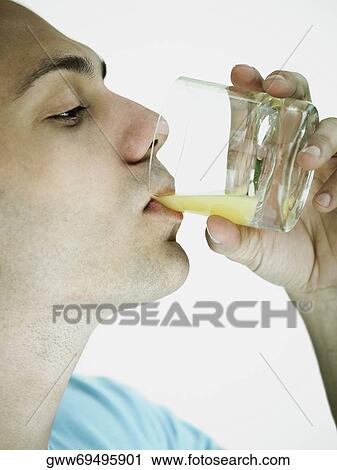 Close-up of a young man drinking a glass of orange juice View Large Photo Image Stock Image - Close-up of a young man drinking a glass of orange juice. Fotosearch