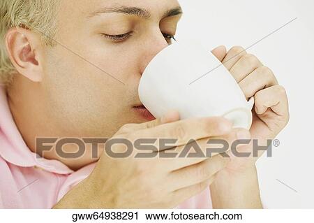 Close-up of a young man drinking coffee from a cup View Large Photo Image Stock Image - Close-up of a young man drinking coffee from a cup. Fotosearch