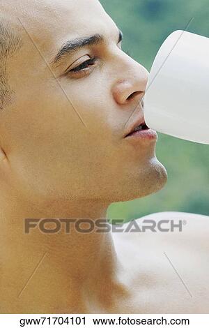Close-up of a young man drinking View Large Photo Image Stock Image - Close-up of a young man drinking. Fotosearch