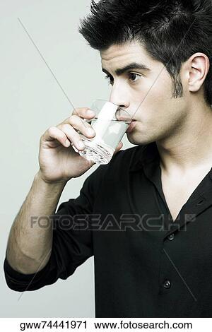 Close-up of a young man drinking water from a glass View Large Photo Image Stock Image - Close-up of a young man drinking water from a glass. Fotosearch