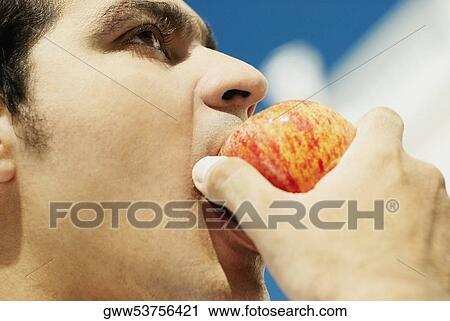 Close-up of a young man eating an apple View Large Photo Image Stock Image - Close-up of a young man eating an apple. Fotosearch