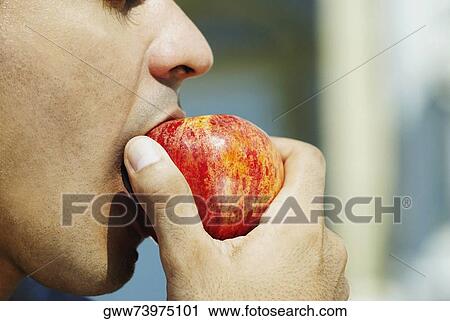 Close-up of a young man eating an apple View Large Photo Image Stock Image - Close-up of a young man eating an apple. Fotosearch