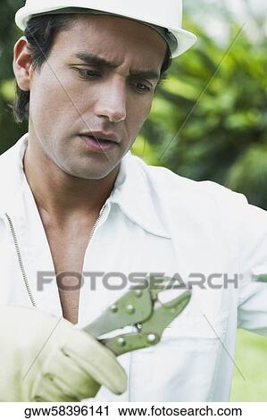 Close-up of a young man holding a pair of pliers View Large Photo Image Stock Image - Close-up of a young man holding a pair of pliers. Fotosearch