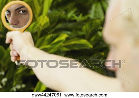Close-up of a young man holding a vanity mirror View Large Photo Image Stock Image - Close-up of a young man holding a vanity mirror. Fotosearch