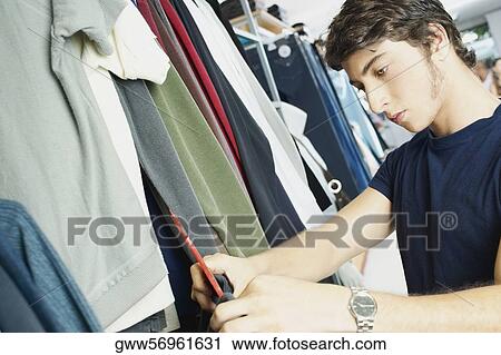 Close-up of a young man in a clothing store View Large Photo Image Stock Image - Close-up of a young man in a clothing store. Fotosearch
