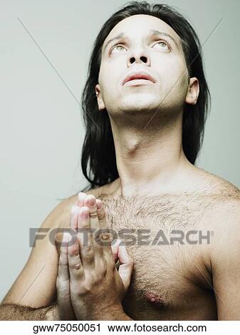 Stock Image - Close-up of a young man in a prayer position. Fotosearch