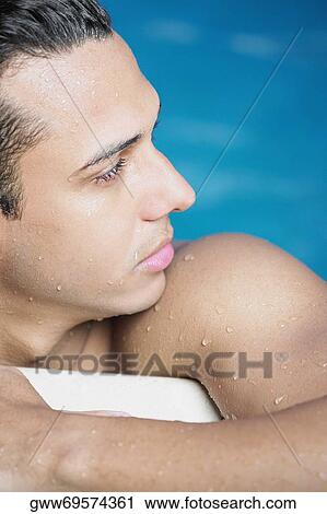 Close-up of a young man leaning on the edge of a swimming pool View Large Photo Image Stock Image - Close-up of a young man leaning on the edge of a swimming pool. Fotosearch