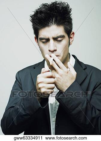 Close-up of a young man lighting a cigarette with a cigarette lighter View Large Photo Image Stock Image - Close-up of a young man lighting a cigarette with a cigarette lighter. Fotosearch