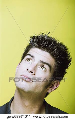 Close-up of a young man looking up and thinking View Large Photo Image Stock Image - Close-up of a young man looking up and thinking. Fotosearch