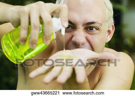 Close-up of a young man pouring oil on his palm View Large Photo Image Stock Image - Close-up of a young man pouring oil on his palm. Fotosearch