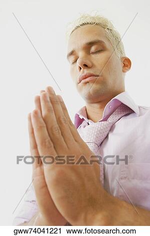 Close-up of a young man praying View Large Photo Image Stock Image - Close-up of a young man praying. Fotosearch