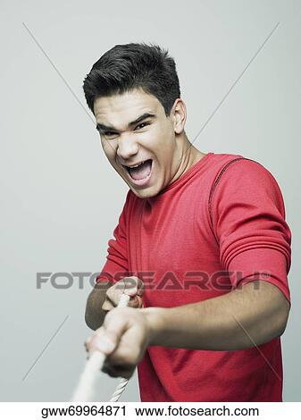 Close-up of a young man pulling a rope View Large Photo Image Stock Image - Close-up of a young man pulling a rope. Fotosearch