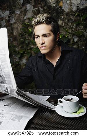 Close-up of a young man reading a newspaper View Large Photo Image Stock Image - Close-up of a young man reading a newspaper. Fotosearch