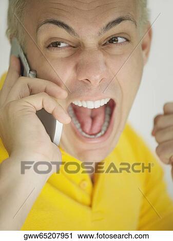 Close-up of a young man screaming on a mobile phone View Large Photo Image Stock Image - Close-up of a young man screaming on a mobile phone. Fotosearch