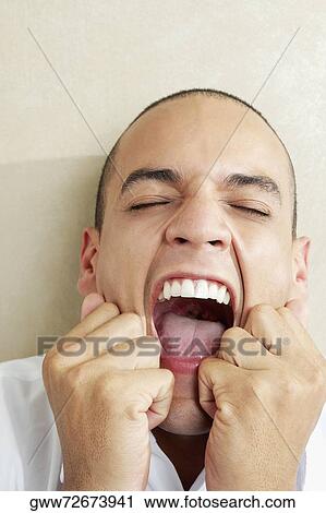 Close-up of a young man shouting with his eyes closed View Large Photo Image Stock Image - Close-up of a young man shouting with his eyes closed. Fotosearch