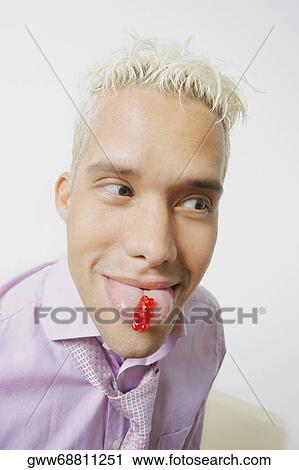 Close-up of a young man sticking his tongue out View Large Photo Image Stock Image - Close-up of a young man sticking his tongue out. Fotosearch