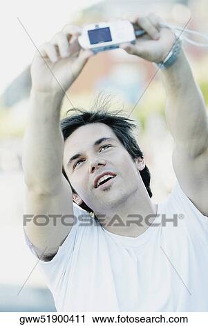 Close-up of a young man taking a photograph of himself View Large Photo Image Stock Image - Close-up of a young man taking a photograph of himself. Fotosearch