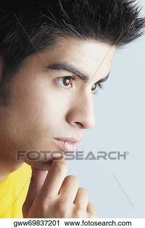 Stock Image - Close-up of a young man thinking. Fotosearch