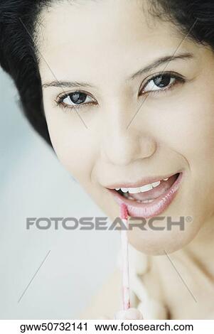 Close-up of a young woman applying lip liner View Large Photo Image Stock Image - Close-up of a young woman applying lip liner. Fotosearch
