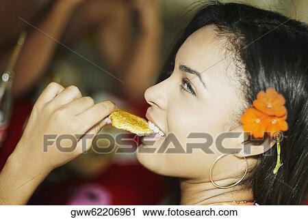 Close-up of a young woman eating a wafer View Large Photo Image Stock Image - Close-up of a young woman eating a wafer. Fotosearch