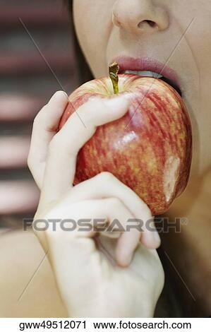 Close-up of a young woman eating an apple View Large Photo Image Stock Image - Close-up of a young woman eating an apple. Fotosearch