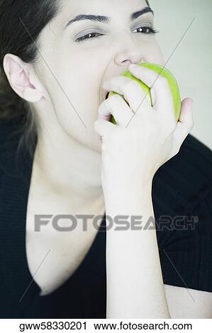 Close-up of a young woman eating an apple View Large Photo Image Stock Image - Close-up of a young woman eating an apple. Fotosearch