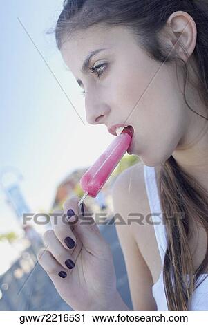 Close-up of a young woman eating an ice-cream View Large Photo Image Stock Image - Close-up of a young woman eating an ice-cream. Fotosearch