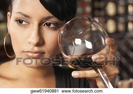 Close-up of a young woman holding a glass of wine View Large Photo Image Stock Image - Close-up of a young woman holding a glass of wine. Fotosearch