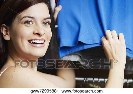 Close-up of a young woman holding a t-shirt View Large Photo Image Stock Image - Close-up of a young woman holding a t-shirt. Fotosearch