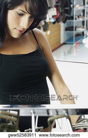 Stock Image - Close-up of a young woman in a clothing store. Fotosearch