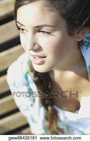 Close-up of a young woman looking away View Large Photo Image Stock Image - Close-up of a young woman looking away. Fotosearch
