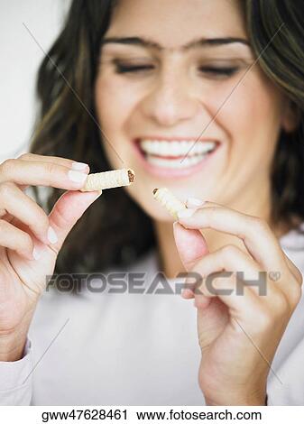 Close-up of a young woman smiling and holding snacks View Large Photo Image Stock Image - Close-up of a young woman smiling and holding snacks. Fotosearch