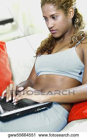 Close-up of a young woman using a laptop View Large Photo Image Stock Image - Close-up of a young woman using a laptop. Fotosearch