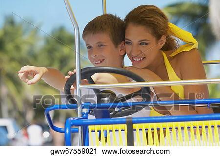 Stock Image - Close-up of a young woman with a boy on a buggy. Fotosearch