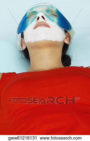 Close-up of a young woman with a facial mask and an eye mask on her face View Large Photo Image Stock Image - Close-up of a young woman with a facial mask and an eye mask on her face. Fotosearch