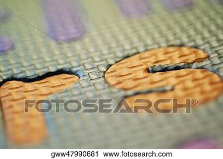 Stock Image - Close-up of alphabets on a patterned surface. Fotosearch